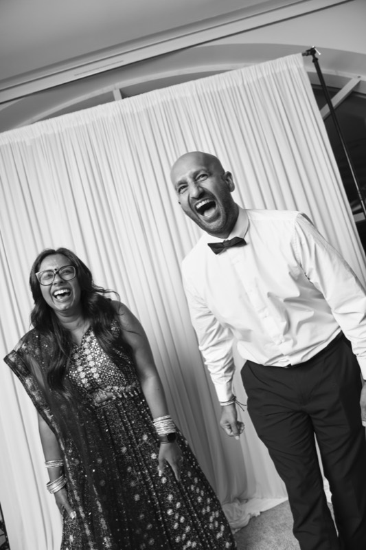 A man and a woman throw their heads back laughing